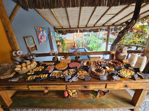 a table with many different types of food on it at Pousada de Charme Emirados in Ilhabela