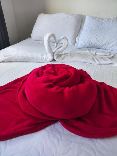 a red blanket and two swans on a bed at Pousada Flor de Lis in Diamantina