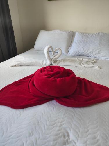 a red dress on a bed with two white towels at Pousada Flor de Lis in Diamantina