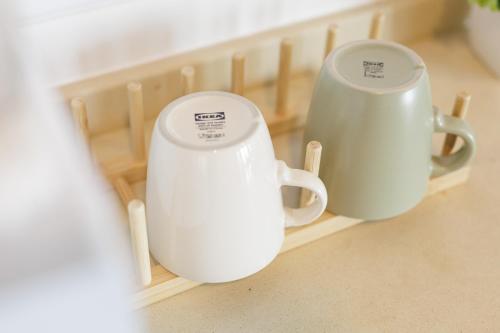 two white coffee mugs sitting on a shelf at 曼谷繁华地区公寓 免费上网 家居家电齐全 in Ban Na Song