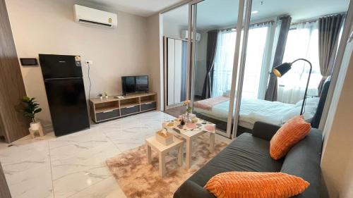 a living room with a blue couch and a bed at 曼谷繁华地区公寓 免费上网 家居家电齐全 in Ban Na Song