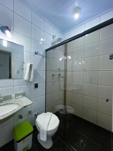 a bathroom with a toilet and a sink and a mirror at Pousada Flor de Lis in Diamantina