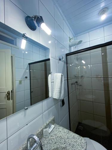 a bathroom with a shower and a sink and a mirror at Pousada Flor de Lis in Diamantina