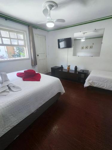 a bedroom with two beds and a mirror at Pousada Flor de Lis in Diamantina