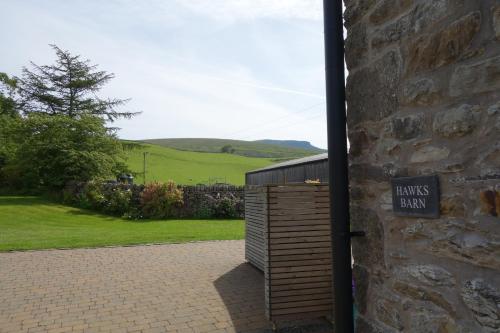 a wooden shed with a sign on the side of a building at Hawks Barn - Horton in Ribblesdale in Horton in Ribblesdale