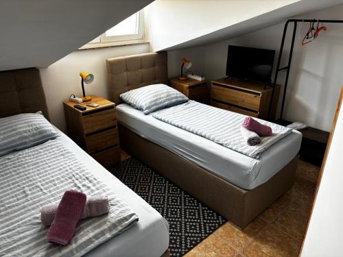 two beds in a small room with a television at Apartmani Rozi in Umag