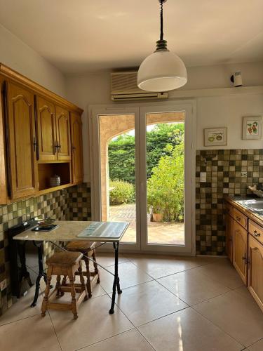 une cuisine avec une table et des chaises ainsi qu'une fenêtre dans l'établissement Villa parfaite pour des vacances, à Hyères