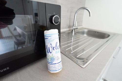una bottiglia di alcol appoggiata accanto a un microonde di Francesco&Chiara - Sweet Apartment a Chioggia
