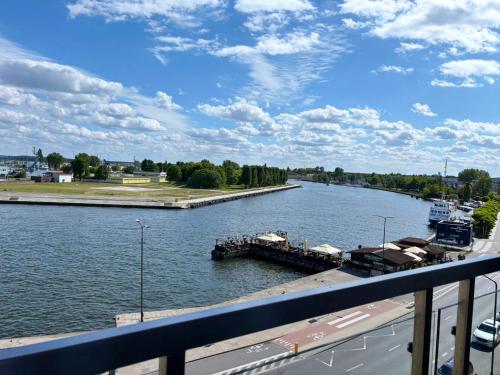 a view of a river with a dock in the water at Villa Concha-Apartamenty Bryza-Parking in Świnoujście