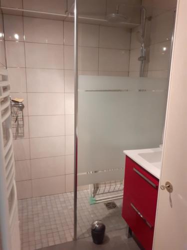 La salle de bains est pourvue d'une douche et d'une armoire rouge. dans l'établissement Maison Les Sables D'olonne, à Les Sables-dʼOlonne