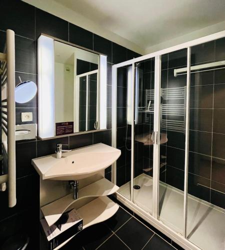 une salle de bain avec un lavabo et une douche en verre dans l'établissement Studio calme sur les rives de l'Orne, à Caen