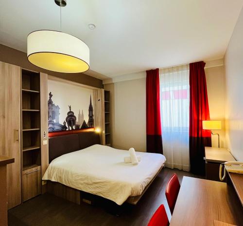 une petite pièce avec un lit, une table et des chaises dans l'établissement Studio calme sur les rives de l'Orne, à Caen