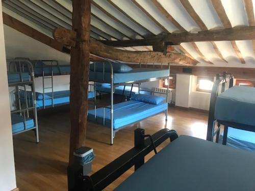 Habitación con 3 literas y mesa. en Albergue MUNICIPAL El Corro de Belorado, en Belorado