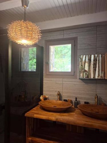 La salle de bains est pourvue de 2 lavabos en bois et d'une fenêtre. dans l'établissement Demeure de charme OLIVIRA, à Vesseaux
