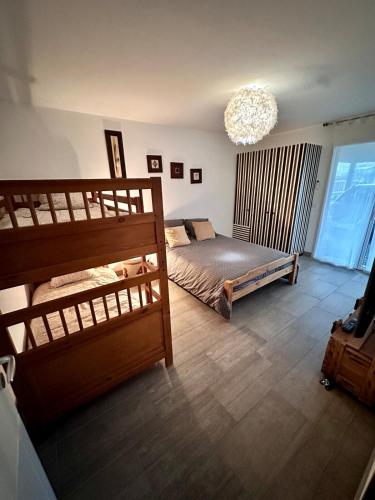 - une chambre avec 2 lits superposés et un lustre dans l'établissement Villa typique bois sur pilotis, à La Teste-de-Buch