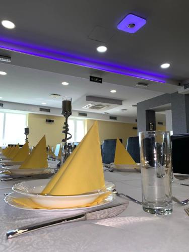 a table with yellow plates and glasses on it at Mirocki-Raj in Miroč