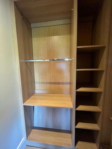 a closet with wooden shelves in a room at Esker Lodge in Tullamore