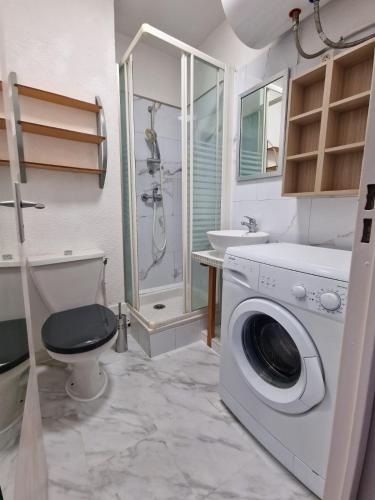 une salle de bain avec machine à laver et toilettes dans l'établissement studio climatisé avec parking, à Canet
