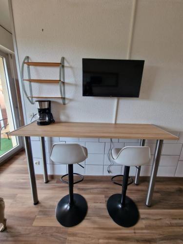 une table en bois avec deux tabourets et un microphone dans l'établissement studio climatisé avec parking, à Canet