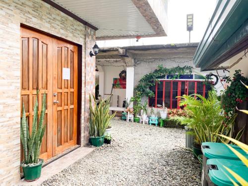 a courtyard with plants and a wooden door at PEPAYEN Homestay in General Luna