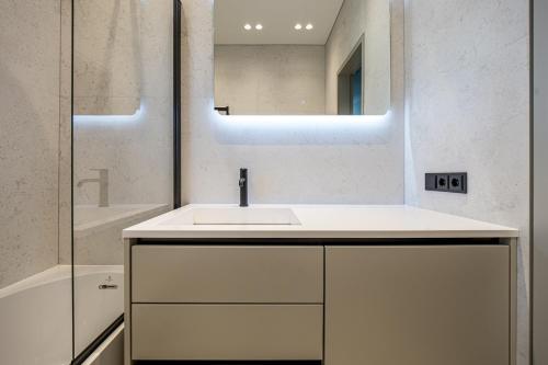 a white bathroom with a sink and a mirror at Baltijos parkas - Šventoji in Šventoji
