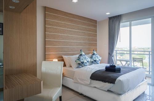 a bedroom with a large bed and a window at NEW amazing studio a private marina in Na Jomtien