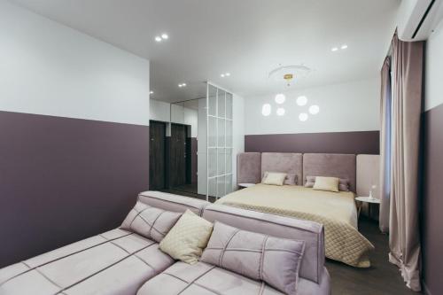 a bedroom with a bed and a couch at ATLANT luxury Premium apartments ТЦ ДЕПОТ in Chernivtsi