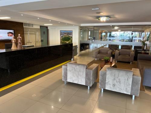 een woonkamer met een bank, een tafel en stoelen bij Flat Marinas 002 in João Pessoa