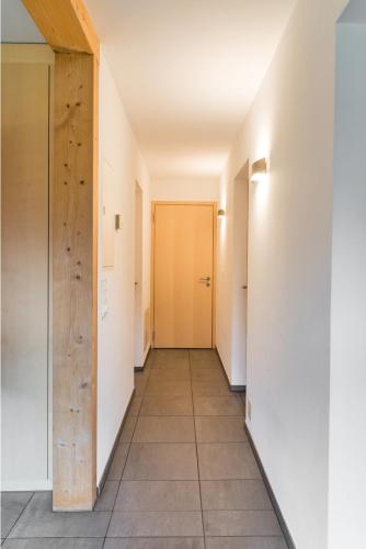 a hallway with a door and a tile floor at Chesa Rivarel - Pontresina in Pontresina