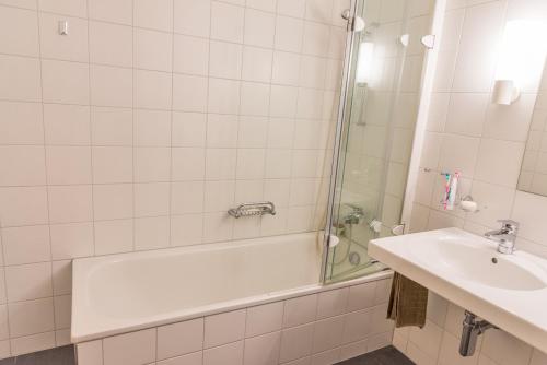a bathroom with a bath tub and a sink at Chesa Rivarel - Pontresina in Pontresina