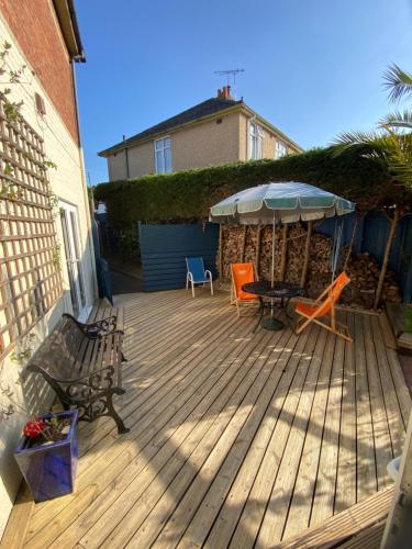 a deck with a table and chairs and an umbrella at 200A Ringwood Road in Poole