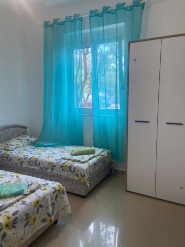 a bedroom with two beds and a blue curtain at Montebello Inn apartments in Ulcinj
