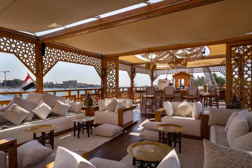 a restaurant with white couches and tables and chairs at EL Hanim Dahabeeyah in Luxor