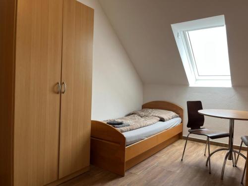 a small bedroom with a bed and a table at APARTMENTS RATZERSDORFER SEEN in 3100 SANKT PÖLTEN in Sankt Pölten