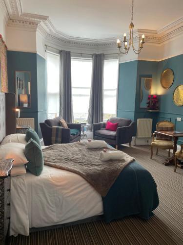 a bedroom with a large bed with blue walls at Albyn Townhouse in Edinburgh