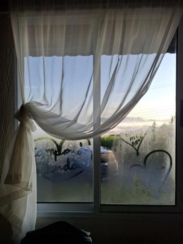 a window with a white curtain in a room at Recanto Due Fratelli in Campos do Jordão