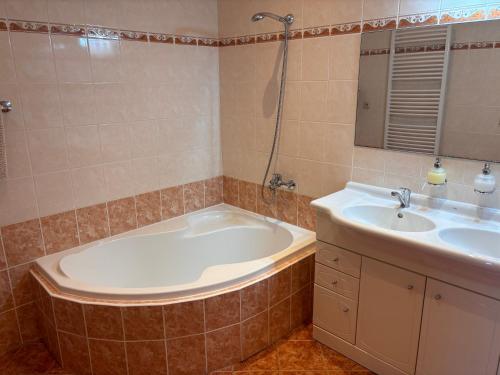 a bathroom with a tub and a sink at Ubytování Jívka 86 in Jívka