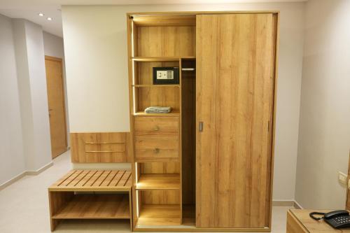 a room with a book shelf and a wooden cabinet at Elite hotel in Sheikh Zayed
