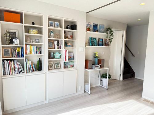 a room with white book shelves filled with books at Pets OK Stunning view of Mt Fuji Near Kawaguchiko Beautiful new facilities ASTLAND in Fujikawaguchiko