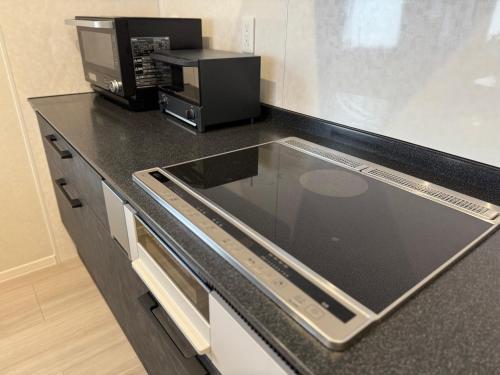 a kitchen with a counter top with a microwave at Pets OK Stunning view of Mt Fuji Near Kawaguchiko Beautiful new facilities ASTLAND in Fujikawaguchiko