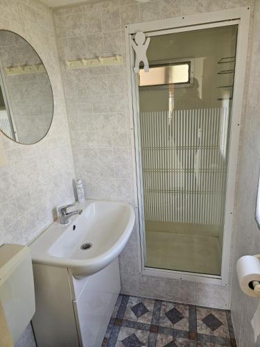 a white bathroom with a sink and a shower at It wiide sicht in Earnewâld