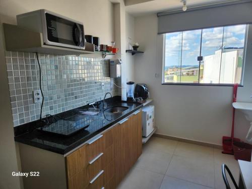 una piccola cucina con lavello e microonde di Studio 302 a 2,8 km da UFV, ar condicionado, vaga a Viçosa
