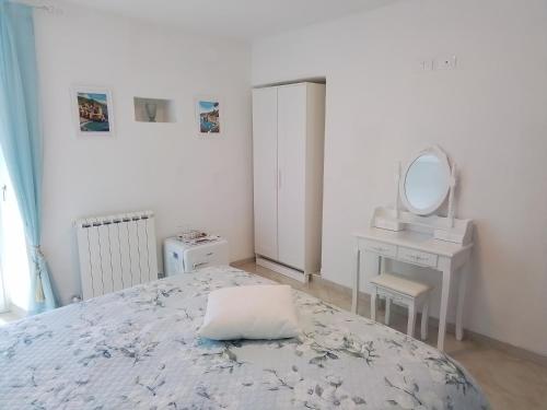 a bedroom with a bed and a dressing table and a mirror at ANITA B&B in Uscio