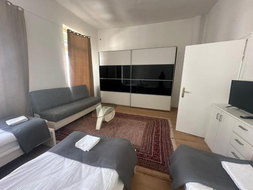 a room with a bed and a couch and a television at Große Ferienwohnung Limburg Diez in Diez