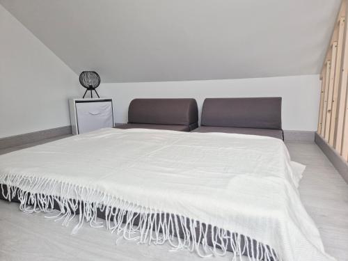 a bedroom with a bed with a white bedspread at Maisonnette entre terre et mer in Saint-Malo-de-Guersac