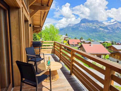 d'un balcon avec des chaises et une table offrant une vue. dans l'établissement Chalet Combloran, à Combloux