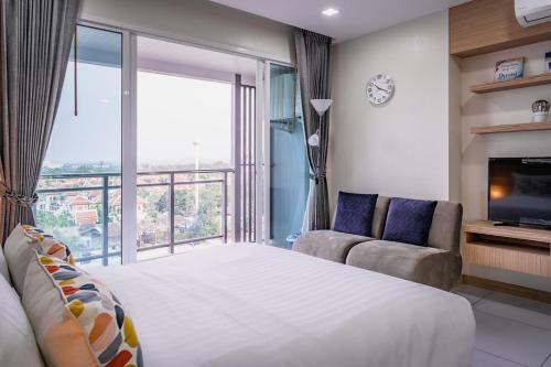 a bedroom with a large bed and a large window at Beautiful studio by the beach with private marina in Na Jomtien