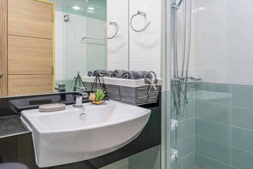 a bathroom with a white sink and a shower at Beautiful studio by the beach with private marina in Na Jomtien