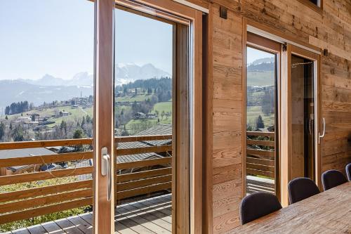 Habitación con puertas de cristal, mesa y sillas. en Chalet Combloran, en Combloux
