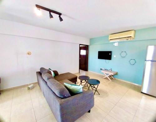 a living room with a couch and a tv at Chrystal Rocks Apartment in Ayia Napa
